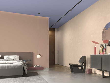 Trendiges Schlafzimmer mit rosa pastellfarbenen Wänden, lavendelfarbener Decke, Hängelampe, Bett, Kommode und geometrischem Spiegel