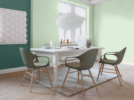 Raumdesign eines modernen Esszimmers mit mintfarbenen Wänden, weißem Tisch, olivfarbenen Stühlen und einzigartiger Pendelleuchte