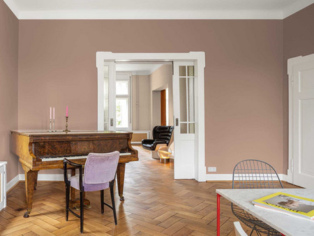 Elegantes fliederfarbenes Wohnzimmer-Interieur mit Flügel, Fischgrätenboden und Türen zum Nebenzimmer