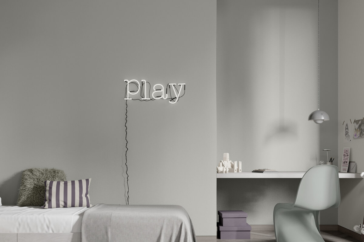 Ausgegrautes Kinderzimmer mit „Play-Leuchtschild“, Bett und Schreibtisch.